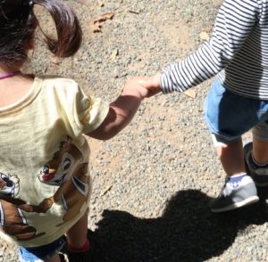 娘とお友達の女の子が手を取り合って歩いている様子（庭園美術館）。女の子同士の友情もとても良いです
